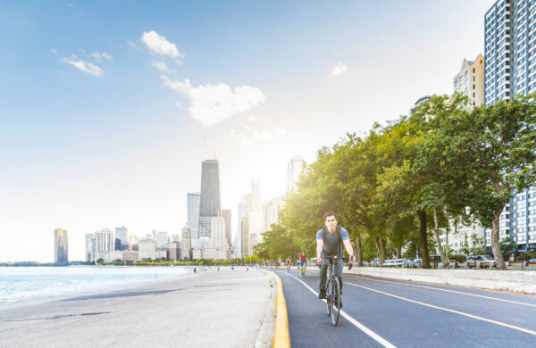 man biking along the shore of Lake Michigan